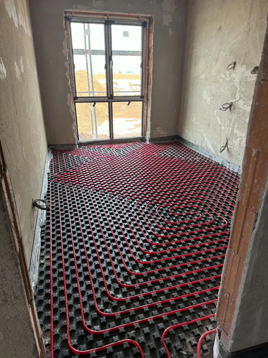 Cameră cu încălzire în pardoseală montată în spirală și în buclă, cu o fereastră mare în fundal